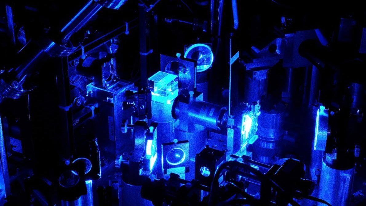 Blaues Laserlicht fällt durch verschiedene Linsen und Kuben