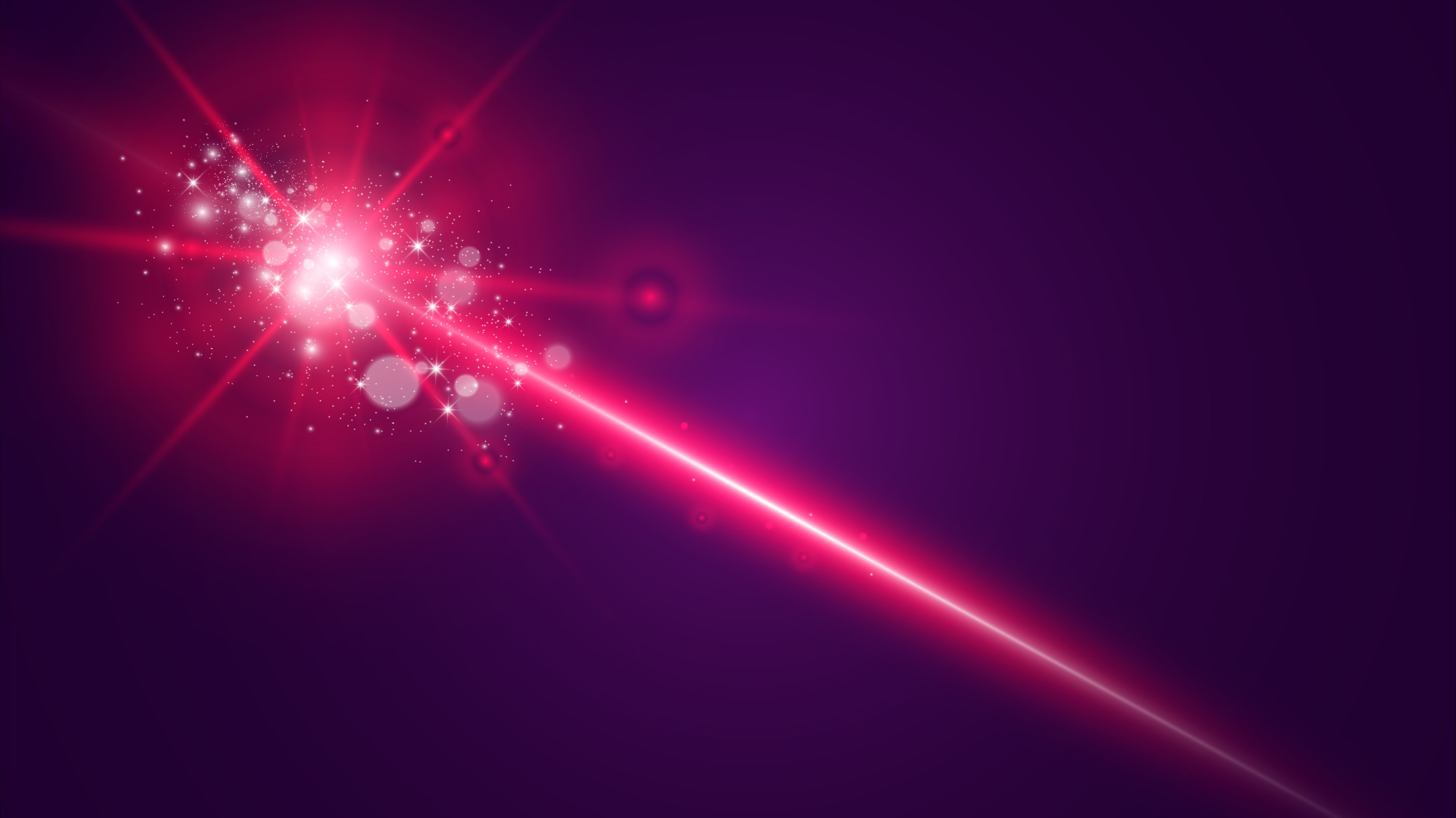 Symbolbild Laserstrahl - roter Strahl vor sternenartigen Hintergrund.