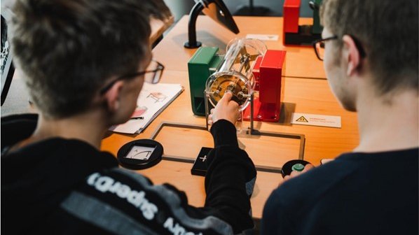 Zwei junge Männer probieren ein Exponat aus