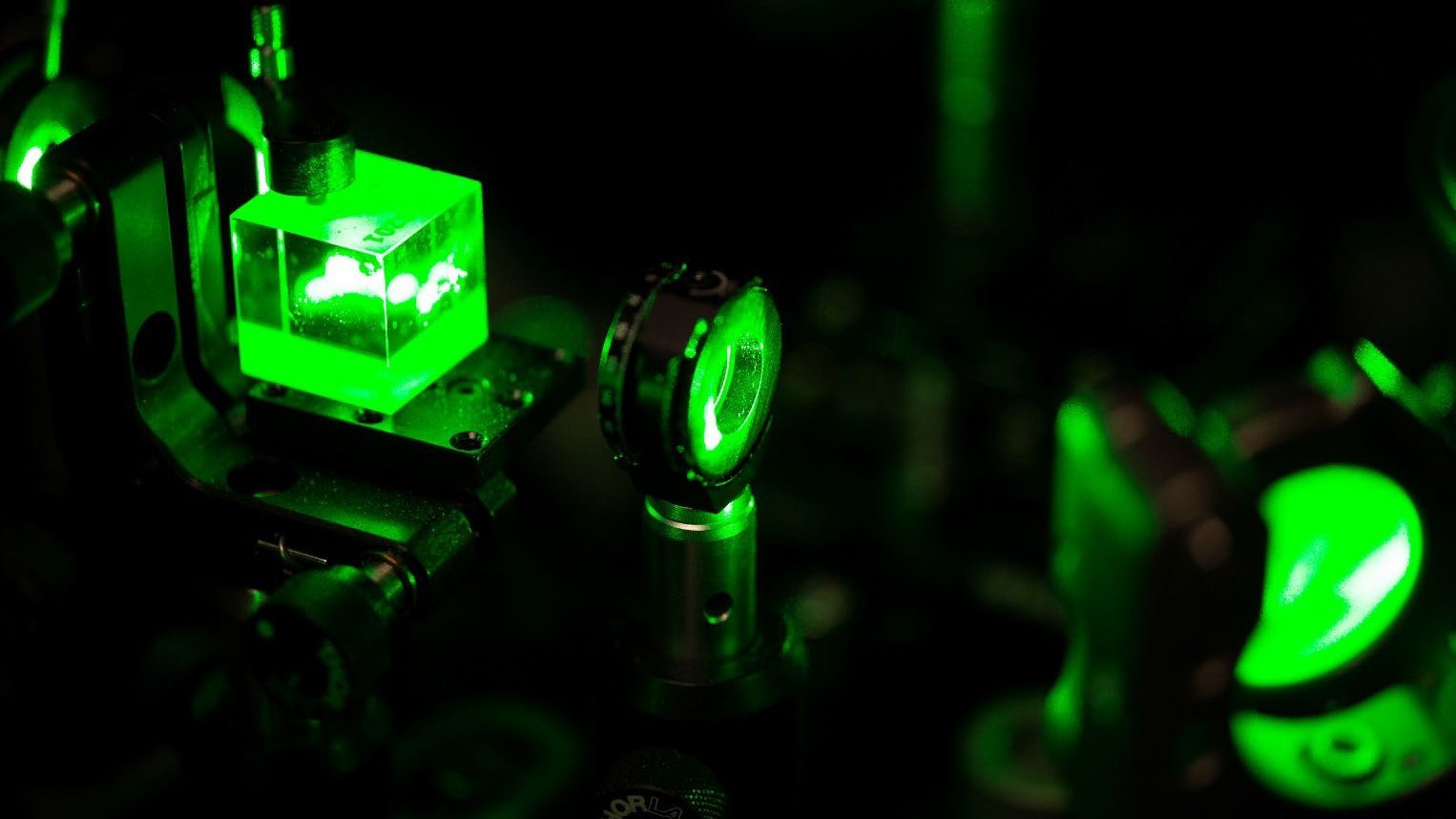 Ein grüner Laser fällt durch ein Glasprisma