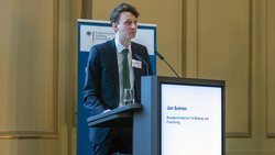 Dr. Jan Suhren auf einem Podium bei der Begrüßungsrede